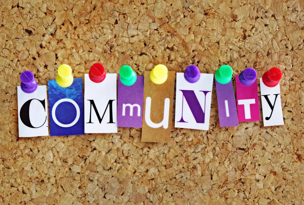 Letters forming "Community" pinned on corkboard.