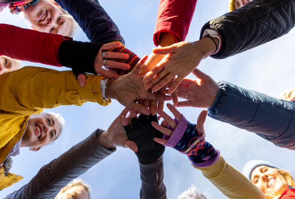 Group of people joining hands together.